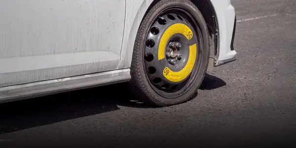 White car with space-saver spare installed.