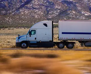 Commercial truck driving down highway in high desert