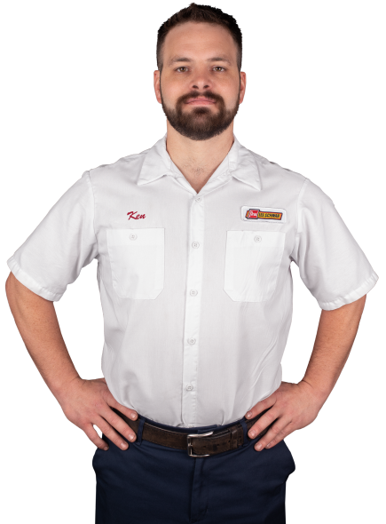 A Les Schwab technician stands arms akimbo. His name is Kenneth